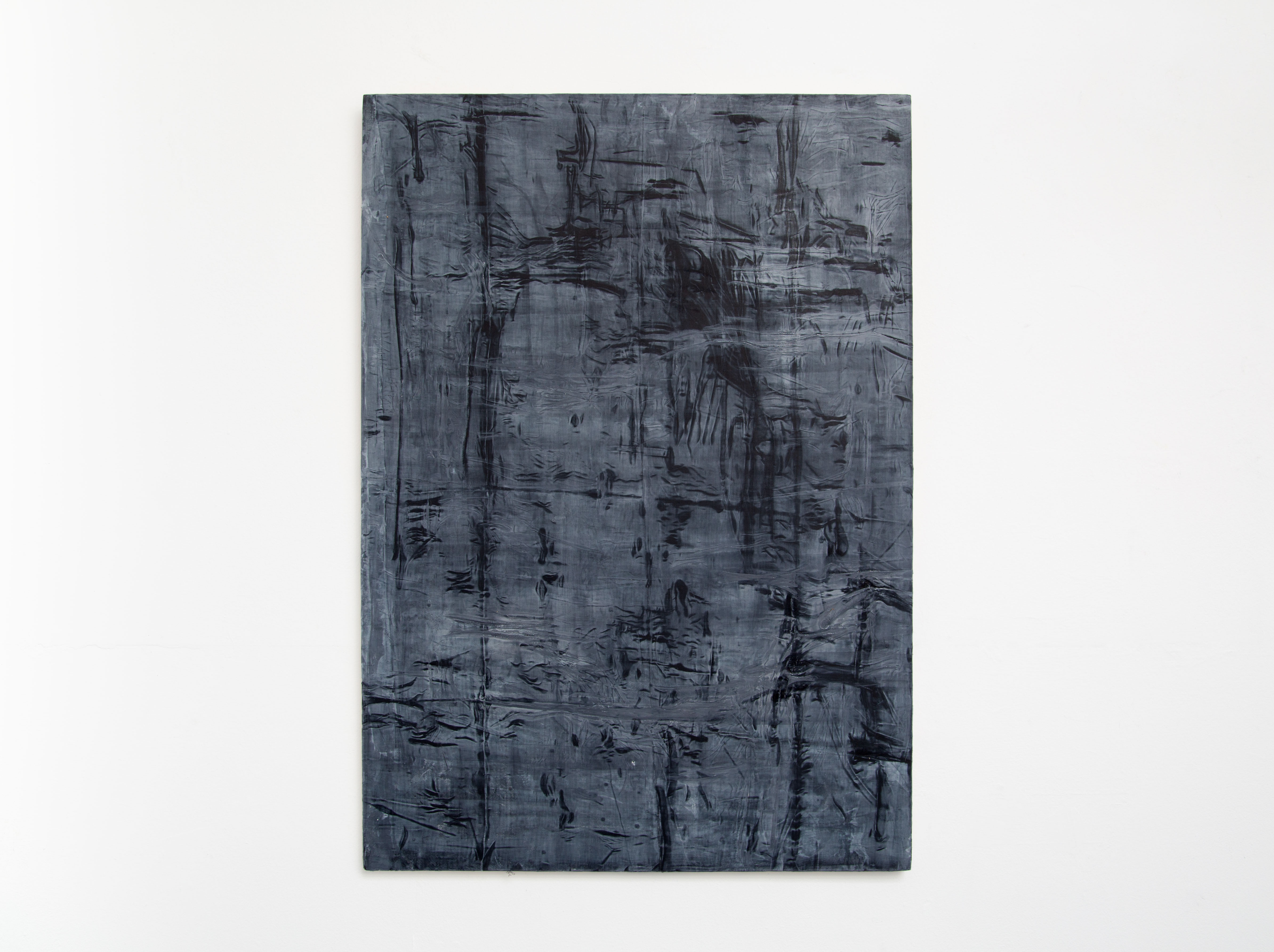 Photograph of a vertical, dark-blue and black sublime abstract painting hung on a white wall.